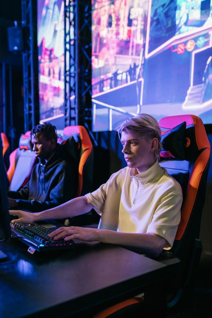 The Art of Drawing Readers In: Your attractive post title goes here Two young men intensely gaming at an esports event with neon-lit screens.